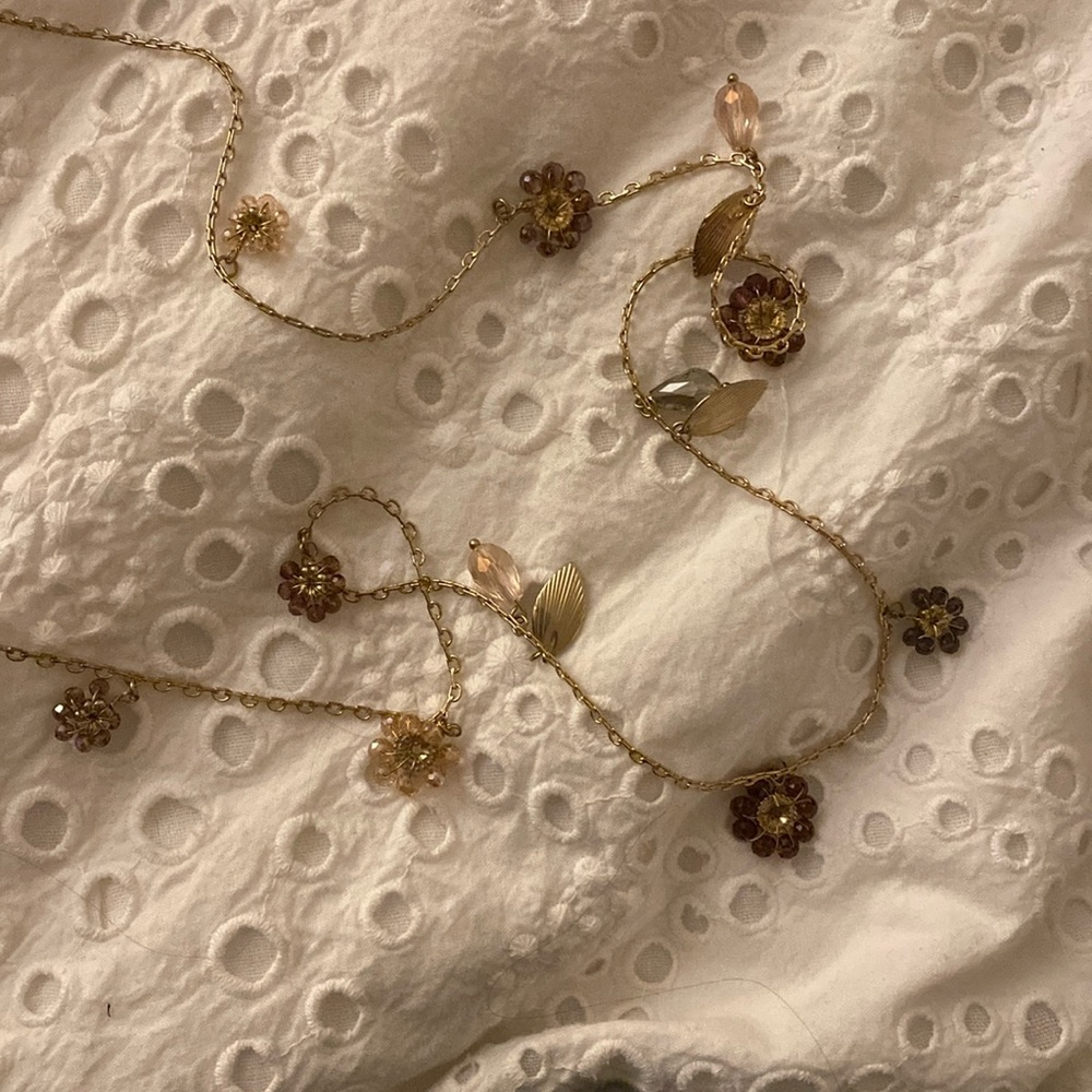 Long gold necklace with floral jewels